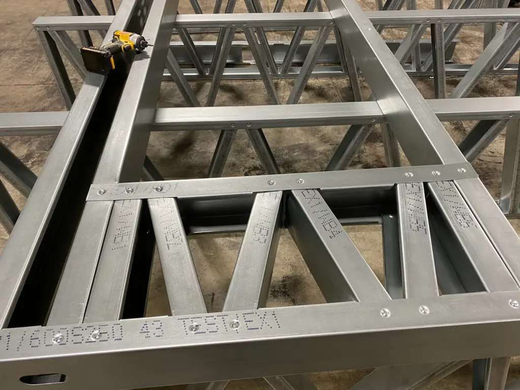 Close-up of a FRAMECAD steel wall panel with labeled, screwed members