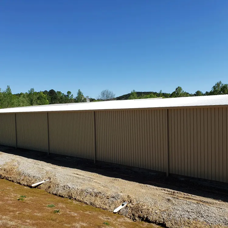 Long metal building sided with tan RW-9 36 wall panels at Falcon's plant in Bessemer, AL