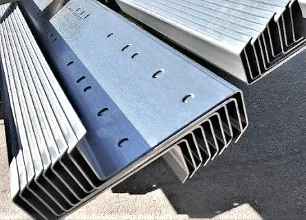 Close-up of nested galvanized Z purlins showing the punched web